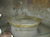 picture of a fountain insde a sauna in ancient pompeii.  The walls and floor of the sauna were heated with steam